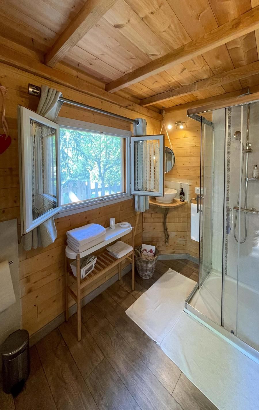 Salle d'eau lumineuse et moderne de notre cabane perchée en Dordogne. Profitez d'une grande douche, d'une vasque élégante sur bois, et du confort de véritables toilettes classiques (sans toilettes sèches) pour un séjour insolite sans compromis sur votre bien-être